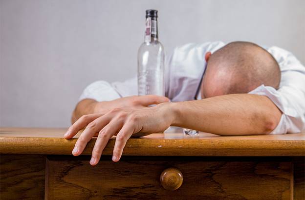 A person lying on a table with a bottle of water on the head Description automatically generated with low confidence