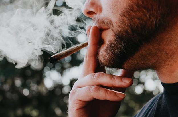 A person smoking a cigarette Description automatically generated with medium confidence